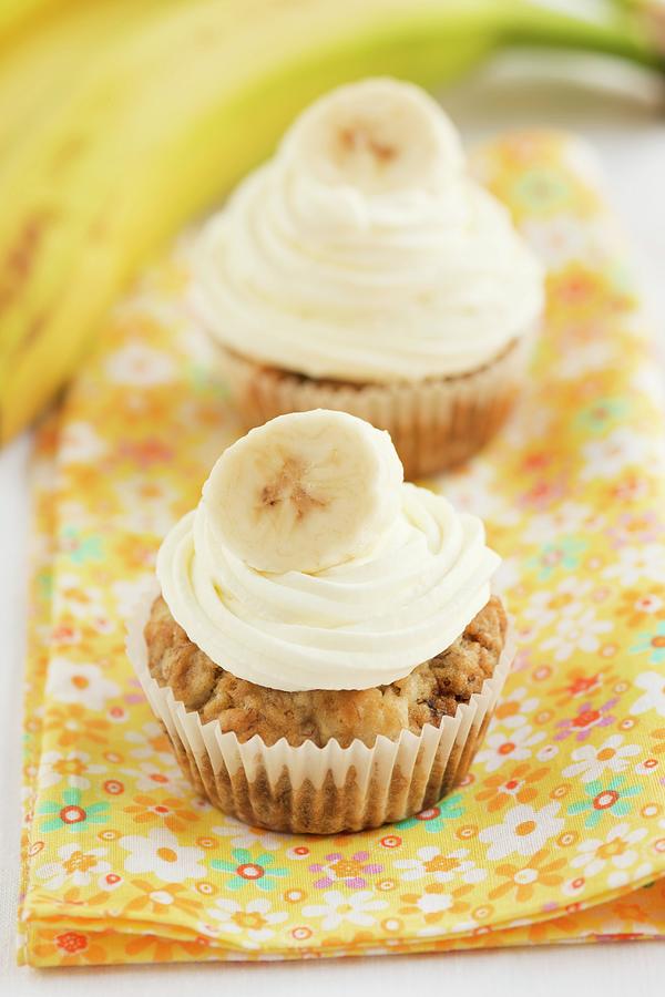Two Banana Cupcakes On A Floral Cloth Photograph by Ewa Rejmer