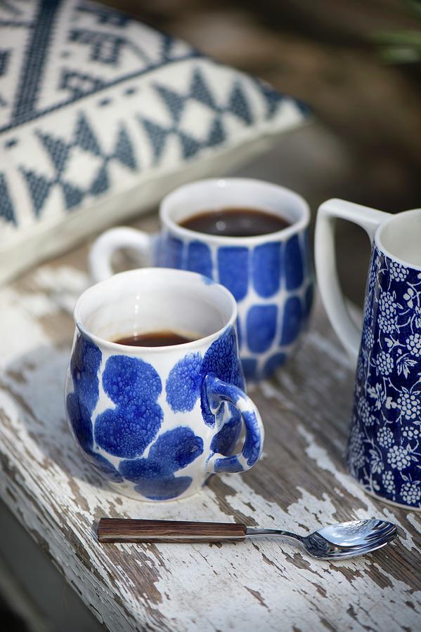 Two Blue-patterned Coffee Cups On Weathered Wooden Board Photograph by Winfried Heinze