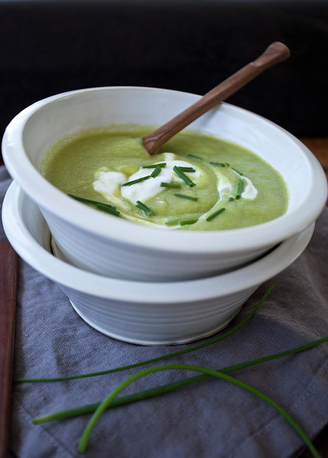 Spring Photograph - Two Bowls Stacked, One With Asparagus Soup, Topped With Creme Fraiche And Chopped Chives by Ryla Campbell