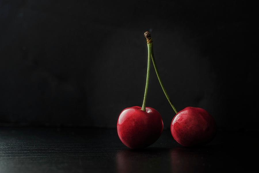 Two Cherries On A Black Surface Photograph by Paolo Lenzi