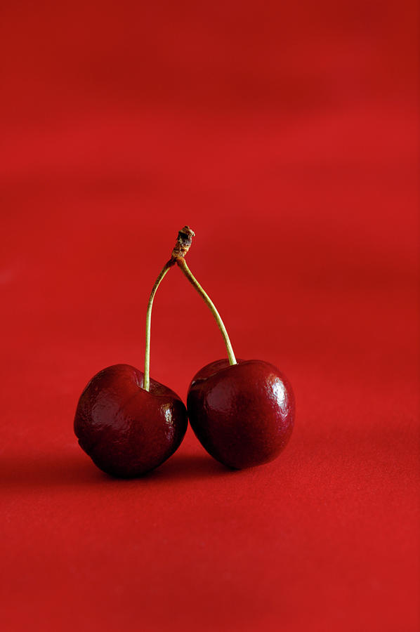 Two Cherries On Red Background Photograph by Flavio Coelho