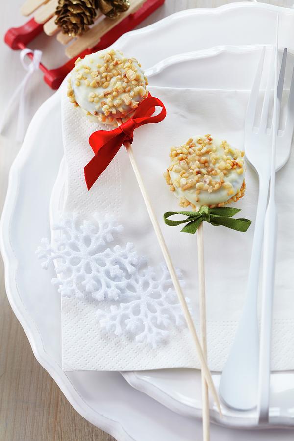 Two Christmas Cake Pops Decorated With White Cooking Chocolate And Nut Brittle Photograph by Franziska Taube