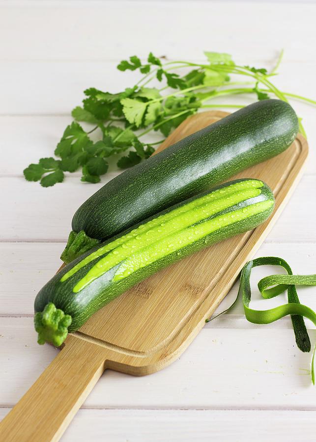 Two Courgettes On A Wooden Board Photograph by Vernica Orti