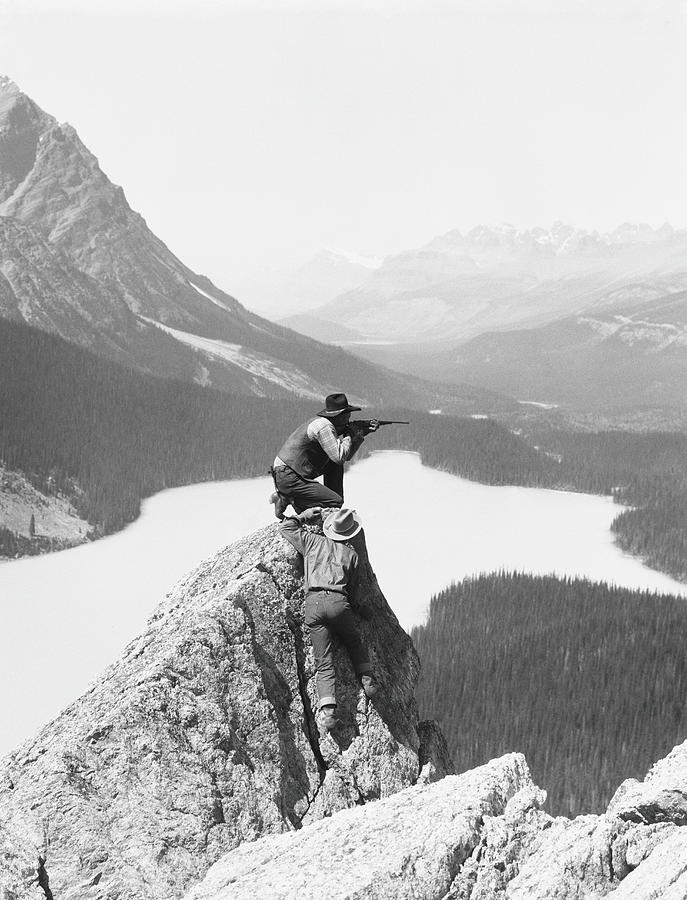 Two Cowboys On Top Of Rocky Crag, One Photograph by H. Armstrong Roberts