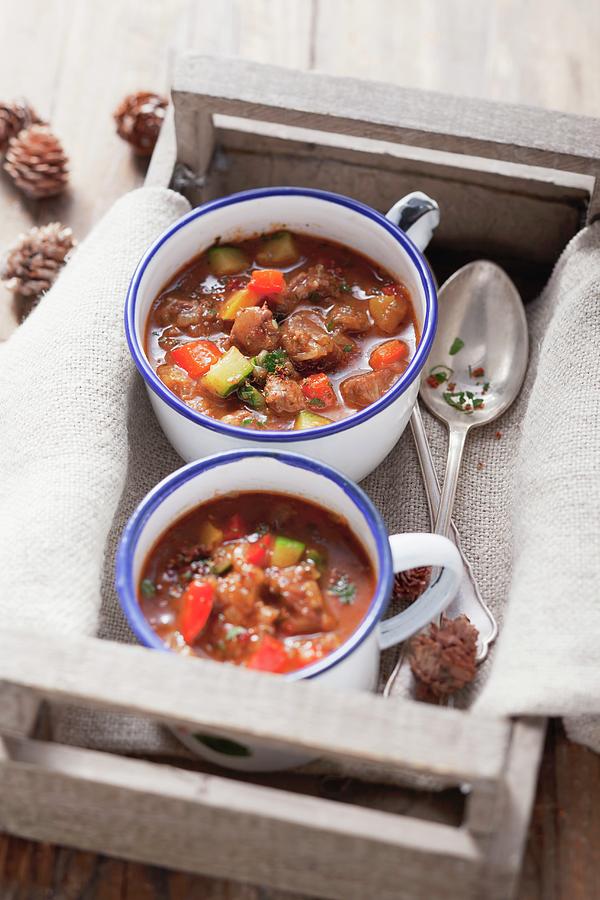 Two Cups Of Goulash Soup In A Crate Photograph by Foodcollection