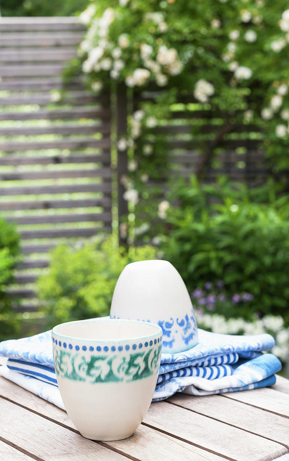 Two Cups With Green And Blue Patterns On Garden Table Photograph by Piru-pictures