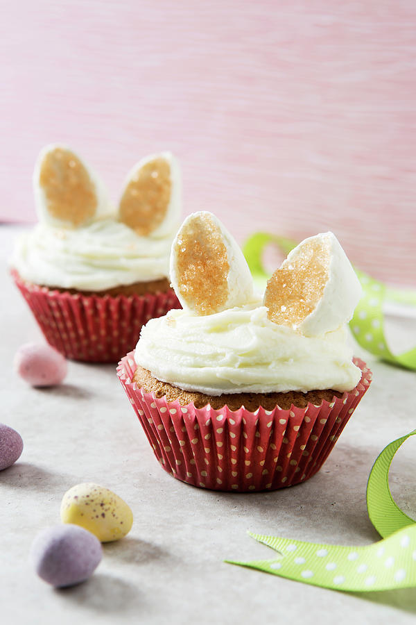 Two Easter Bunny Cupcakes With Marshmallow Ears In A Pastel Setting With Mini Eggs In The Foreground Photograph by Stacy Grant