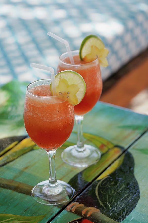 Two Exotic Drinks Garnished With Limes And Star Fruit Photograph by ...