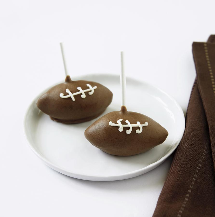 Two Football Cake Pops On A Plate Photograph by Dinner, Allison