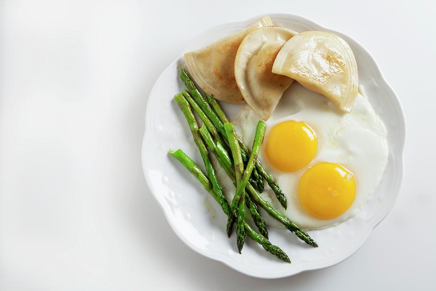 Two Fried Eggs With Pierogi And Green Asparagus Photograph by George Crudo
