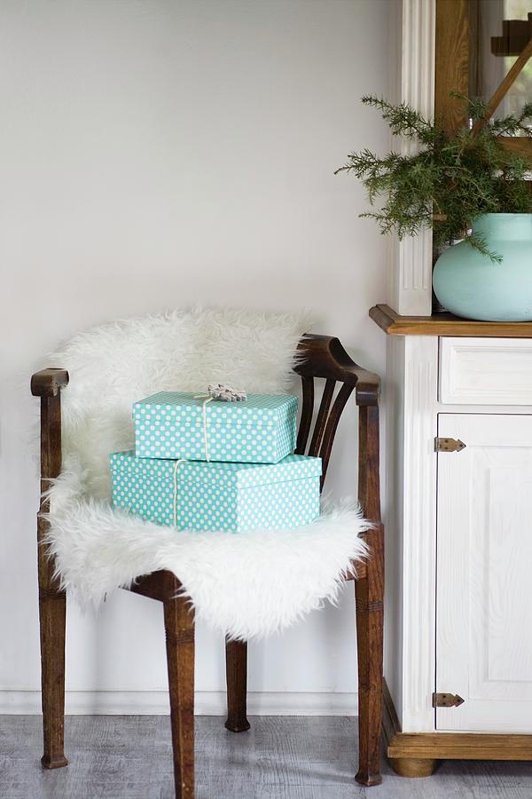 Two Gifts On Sheepskin On Corner Chair Photograph by Alicja Koll