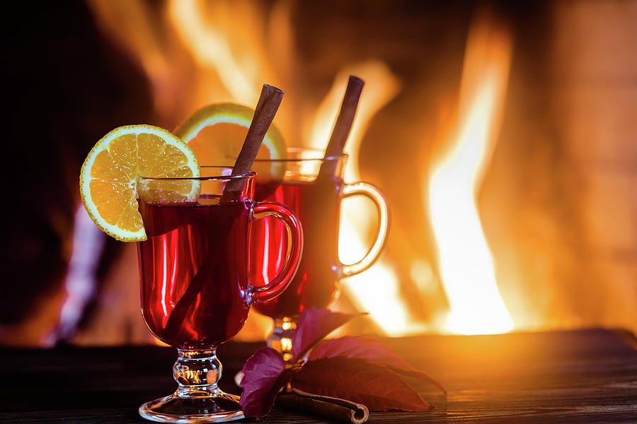 Mulled Wine Glasses On The Table In Front Of The Burning Fireplace