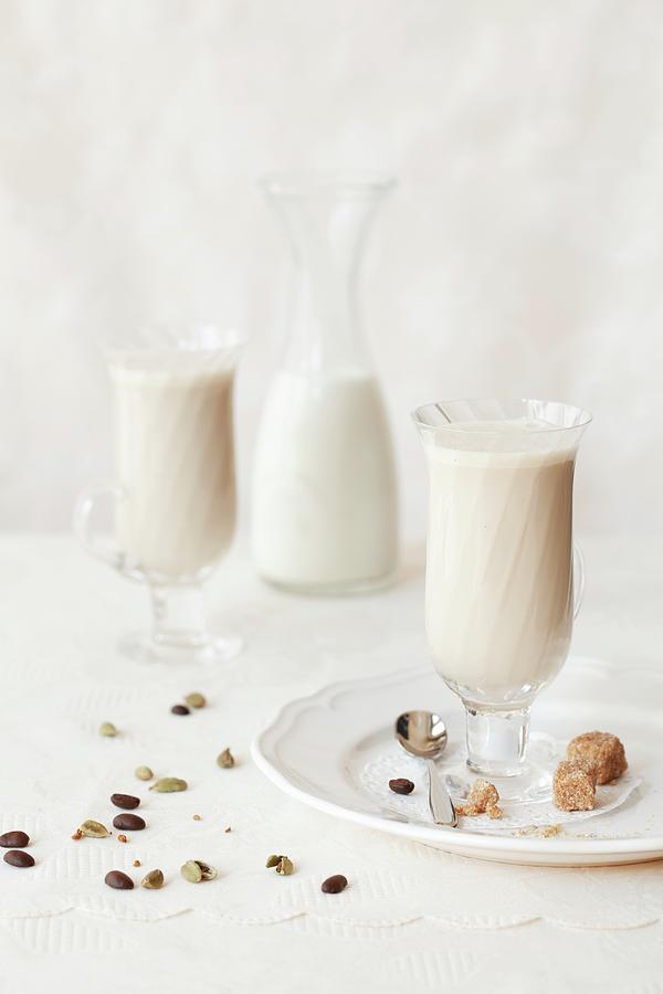 Two Glasses Of Spiced Cafe Au Lait With Sugar Cubes, Coffee Beans And Cardamom Pods Photograph by Jane Saunders