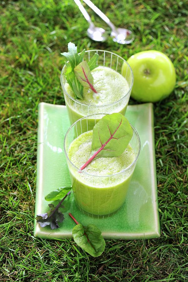 Two Green Smoothies Garnished With Lettuce And Apple In The Garden Photograph by Antje Plewinski