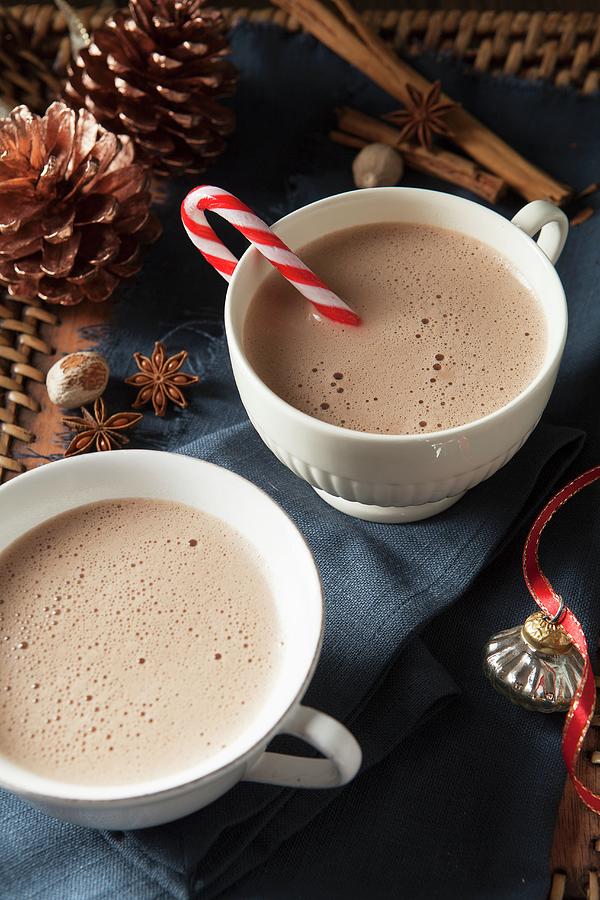 Two Large White Mugs Of Frothy Hot Chocolate one With A Candy Cane For Christmas Photograph by Stacy Grant