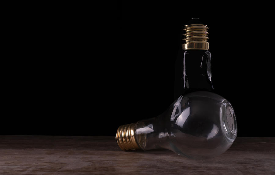 Two light bulbs arranged on a wooden table by Vincent Billotto Two light bulbs arranged on a wooden table by Vincent Billotto