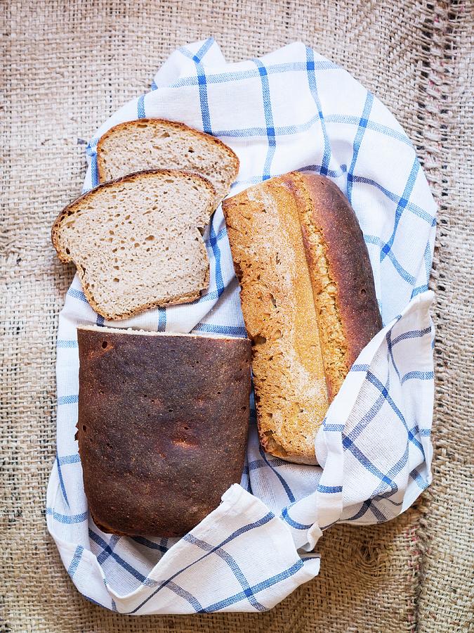 Two Loaves Of Homemade Sourdough Rye Bread On A Checked Tea Towel Photograph by Magdalena Paluchowska