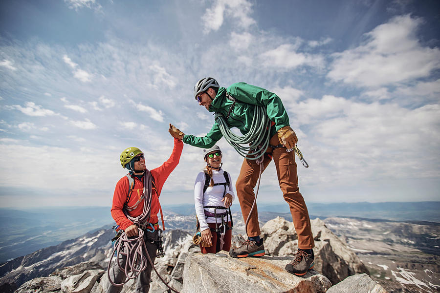 Grand Teton National Park Photograph - Two Men High Five At Summit Of Grand Teton While Third Person Watches by Cavan Images