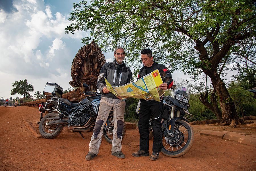 Rural Scene Photograph - Two Men Looking At Map On An Adventure Motorbike Ride In Cambodia by Cavan Images