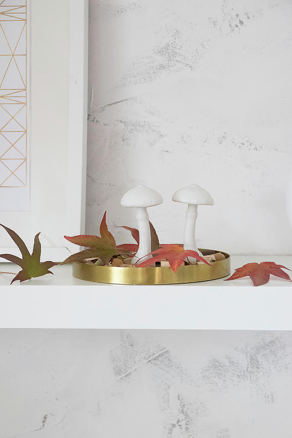 Two Mushroom Ornaments And Autumn Leaves On Golden Tray Photograph by Astrid Algermissen