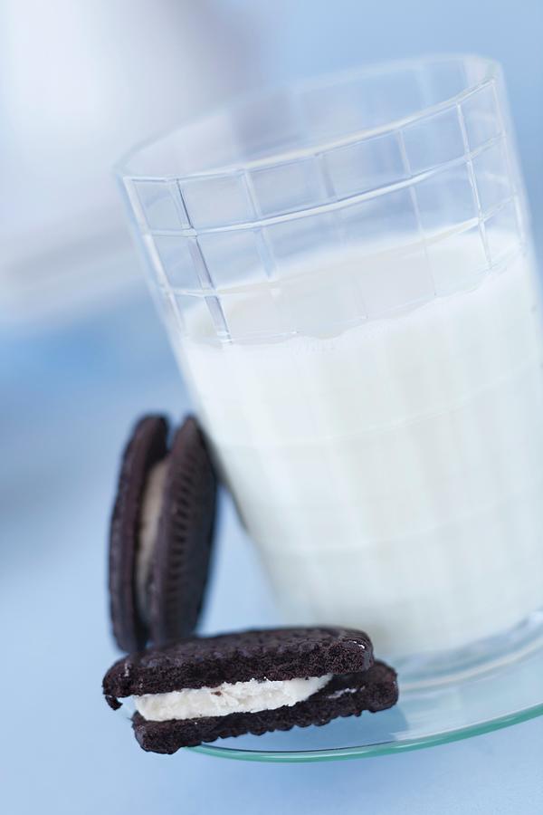 Two Oreos Next To A Glass Of Milk Photograph by Katharine Pollak