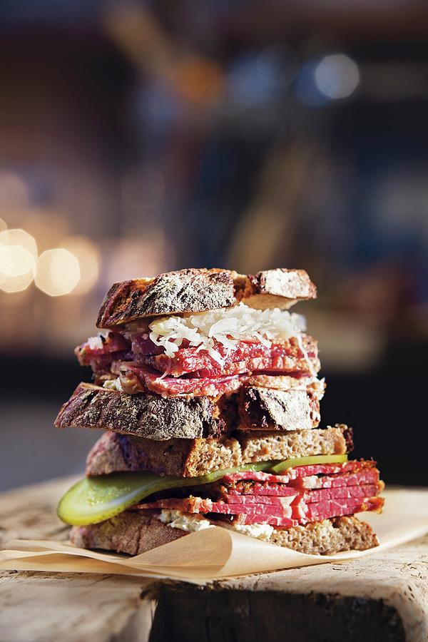 Two Pastrami Sandwiches Stacked One On Top Of The Other Photograph by Jalag / Joerg Lehmann