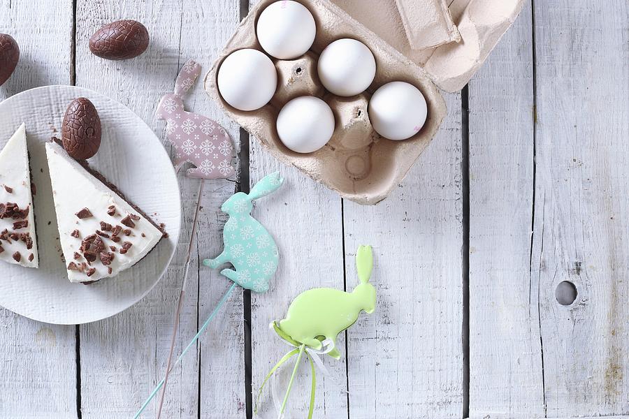 Two Pieces Of Easter Cake With Chocolate Eggs, Easter Rabbits, And An Egg Carton Photograph by Zita Csig