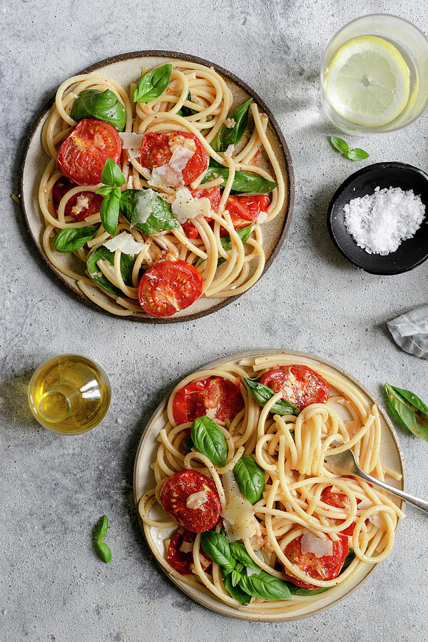 Two Plates Of Bucatini Pasta With Roasted Tomatoes And Basil Photograph by Anna Wierzbinska