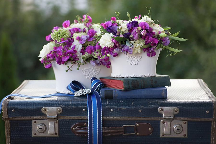 Two Romantic Flower Arrangements And Antiquarian Books On Vintage Suitcase Decorated With Ribbon Photograph by Alicja Koll