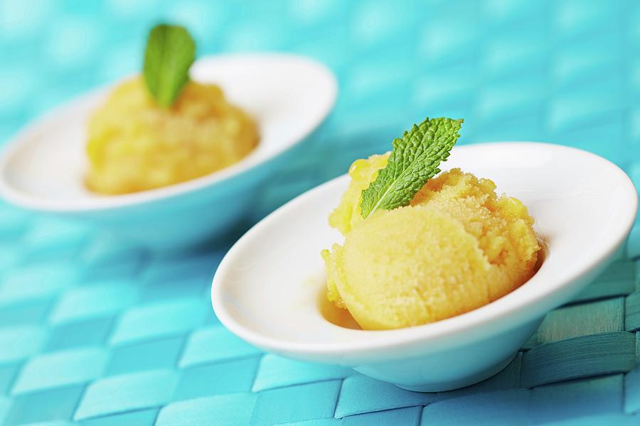 Two Scoops Of Home-made Passion Fruit Sorbet With Fresh Mint Photograph by Robert Kneschke