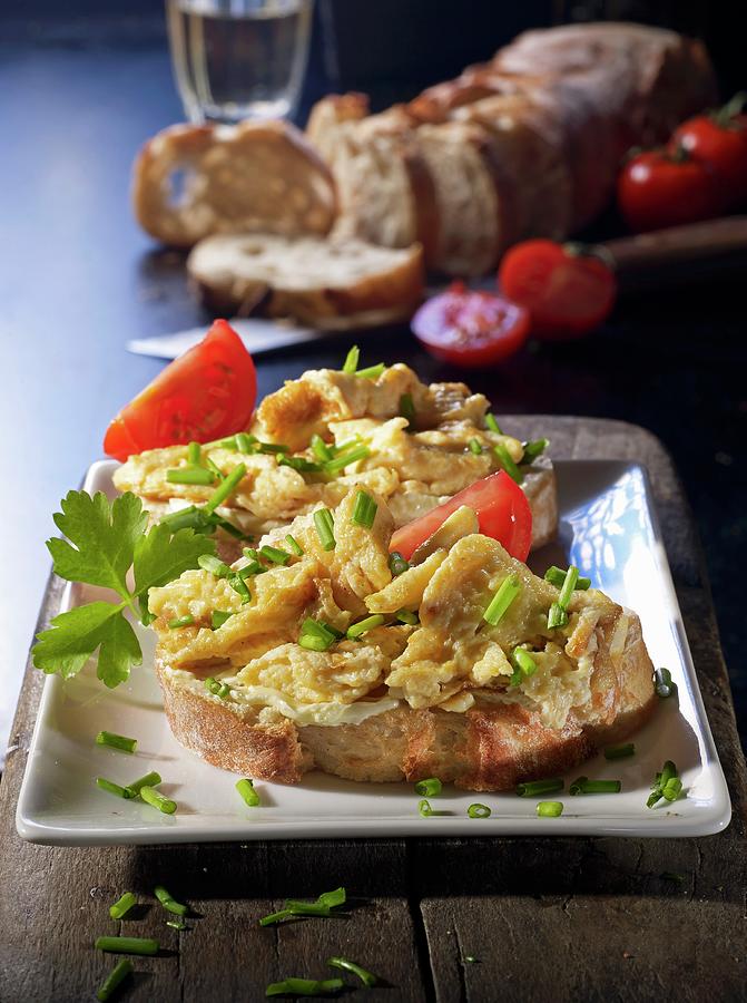 Two Slices Of Baguette Topped With Scrambled Egg And Tomatoes Photograph by Ludger Rose
