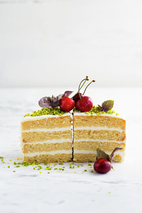 Two Slices Of Cake With A Cream Filling Garnished With Cherries And Pistachios Photograph by Katrin Winner