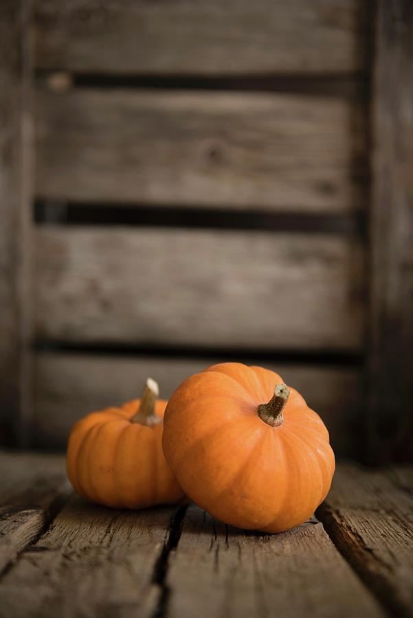 Two Small Pumpkins On A Wooden Surface Photograph by Sonia Chatelain