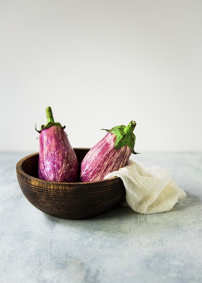 Two Striped Graffiti Aubergines In A Wooden Bowl Photograph by Lisa Rees