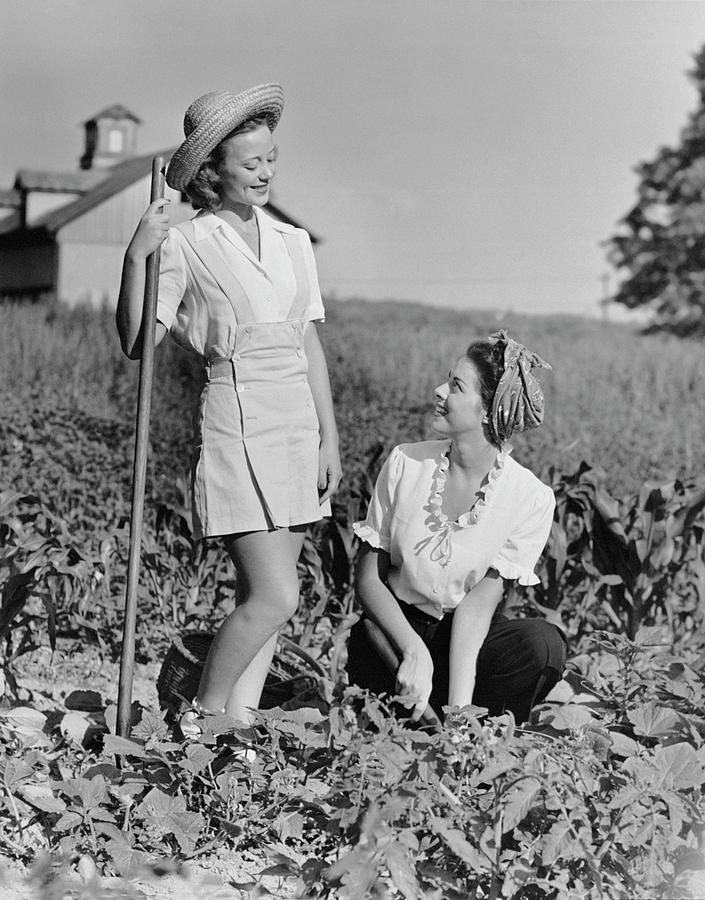 Two Women Gardening In Field Photograph by George Marks