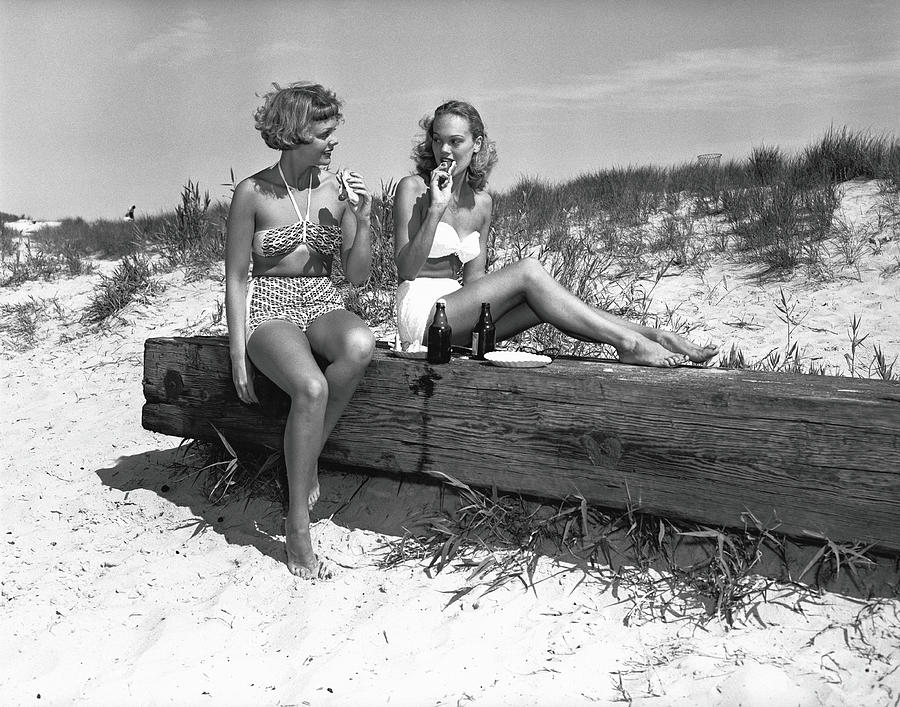Two Women In Bikini Eating Snack On Photograph by George Marks