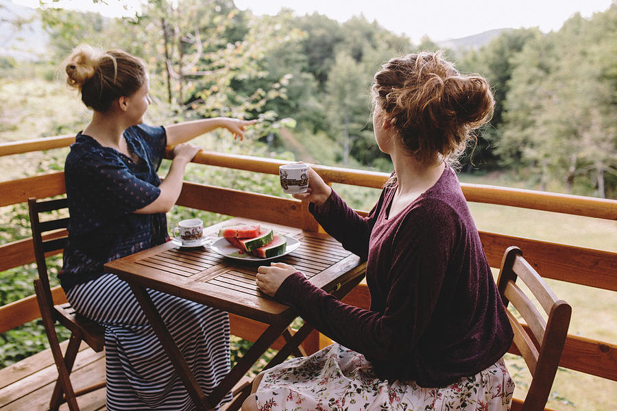 Two Women Sitting On Balcony And Drinking Coffee Photograph By Cavan Images 