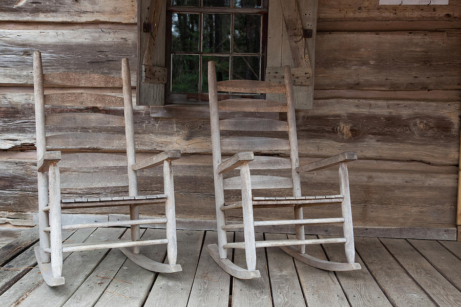 Two Wooden Rocking Chairs On The Wooden Porch Of A Log Cabin