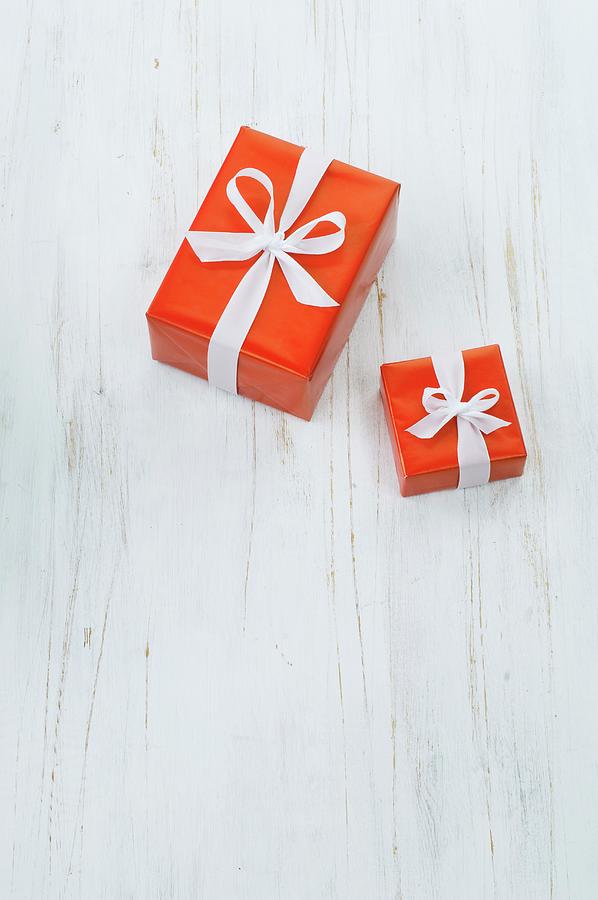 Two Wrapped Gifts On White Floor Photograph by Achim Sass