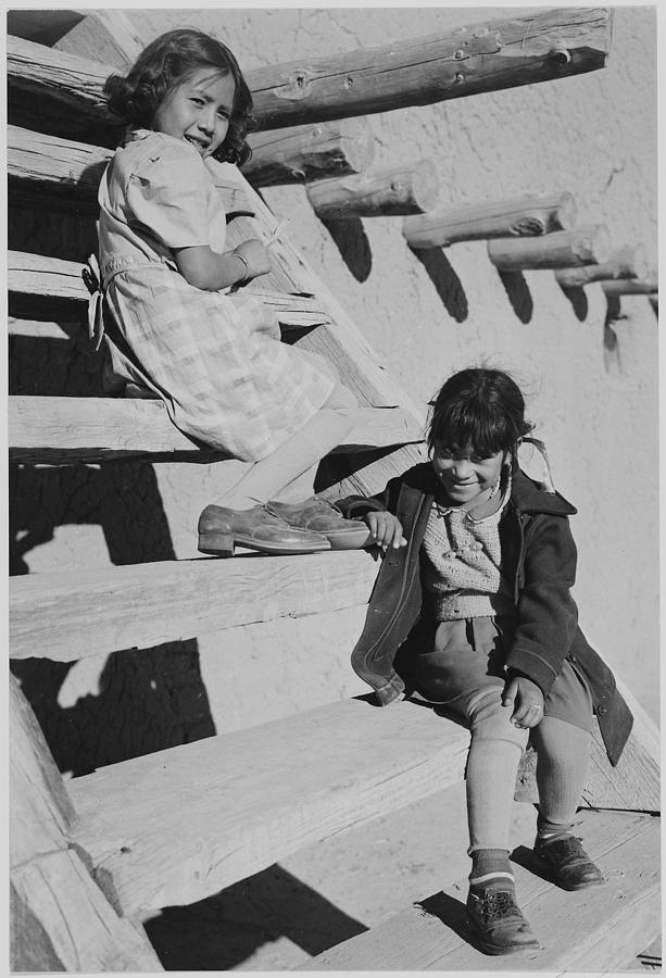 Two young girls sitting on steps. At San Ildefonso Pueblo New Mexico 1942. (vertical orientation) 1942 Painting by Ansel Adams
