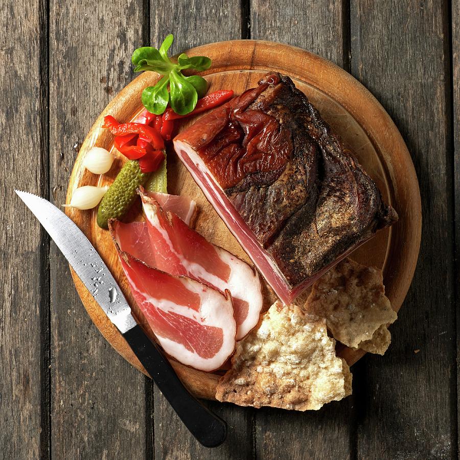 Tyrolean Bacon On A Board Schttelbrot crispy Unleavened Bread From South Tyrol With Conichons, Lambs Lettuce And A Knife Photograph by Ludger Rose