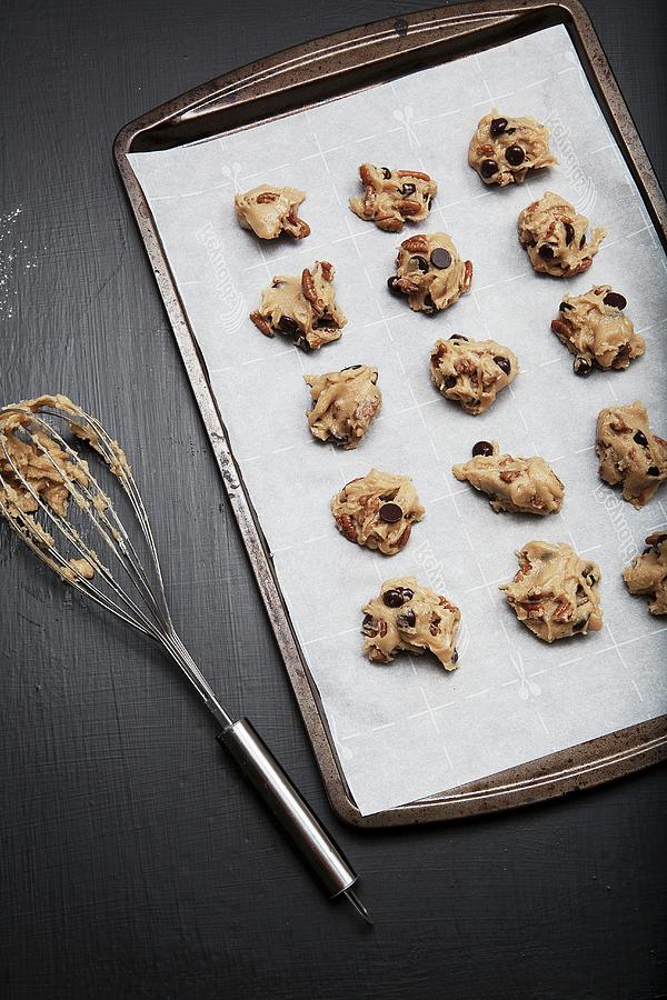 Unbaked Chocolate Chip And Pecan Nut Cookies On A Baking Tray Photograph by Vfoodphotography