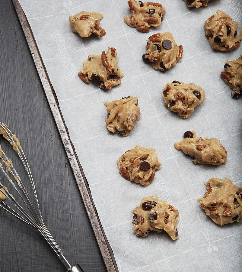Unbaked Chocolate Chip And Pecan Nut Cookies On Baking Paper Photograph by Vfoodphotography