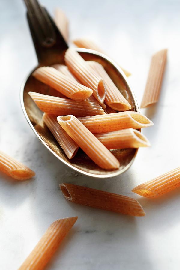 Uncooked Red Penne Rigate On A Spoon Photograph by Viola Cajo