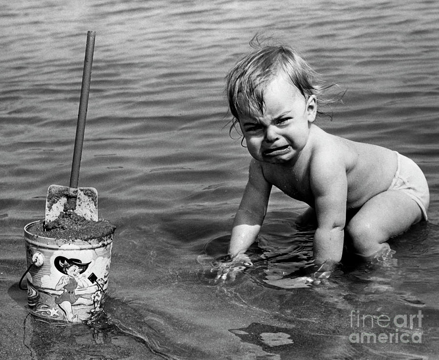 Unhappy Toddler In Cold Water At Beach Photograph by Bettmann