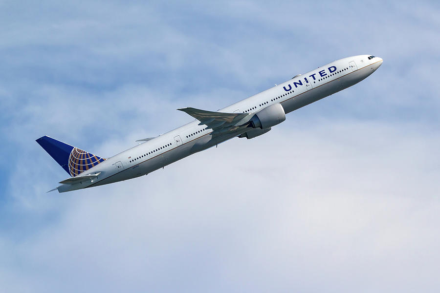 United Airlines Boeing 777-300 in flight. Photograph by Rick Pisio