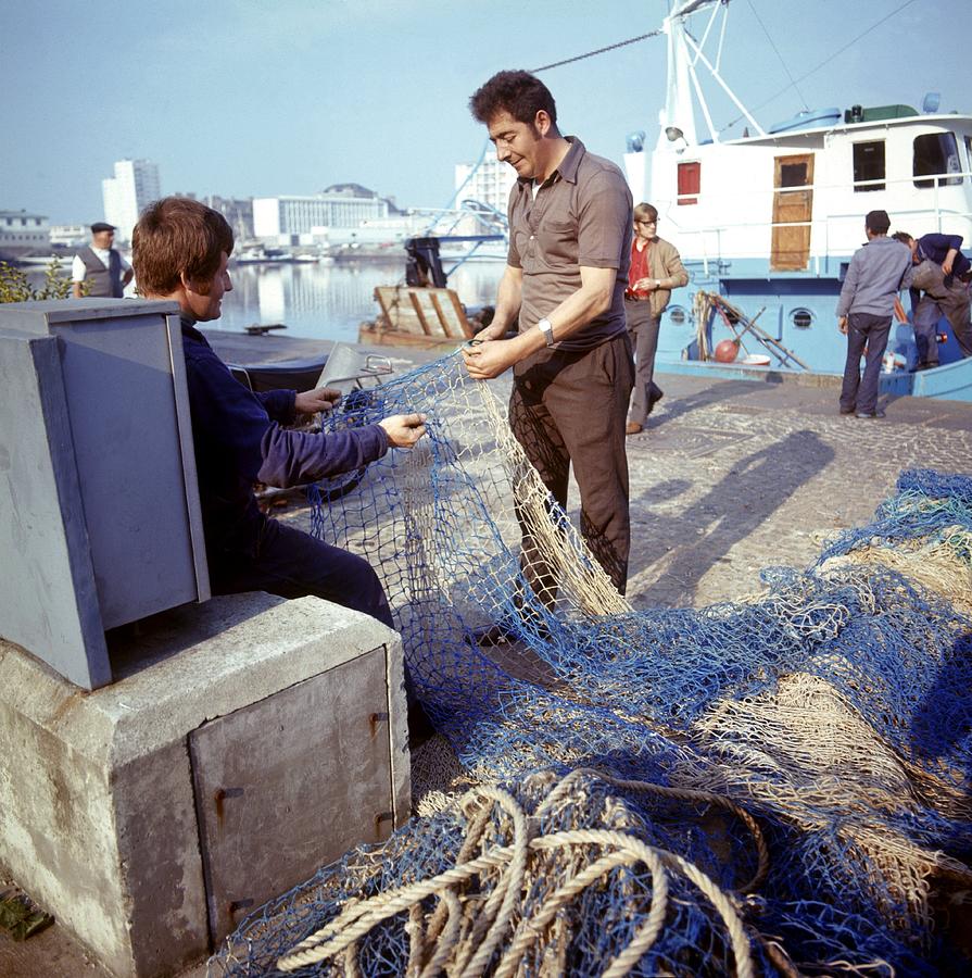 Untangling Fishing Nets At The Harbour Photograph by Keystone-france