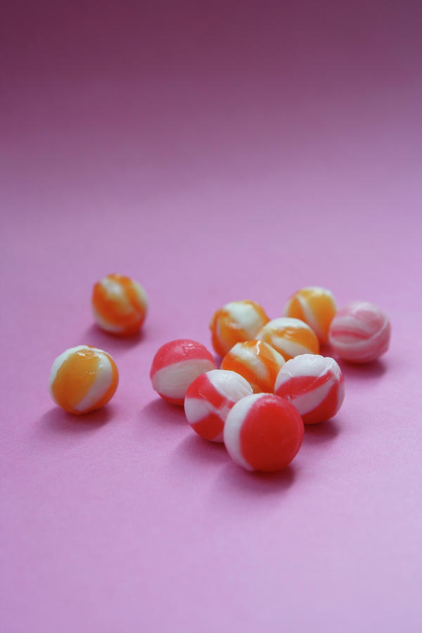 Unwrapped Hard Candies On Pink Paper Photograph by Asia Images