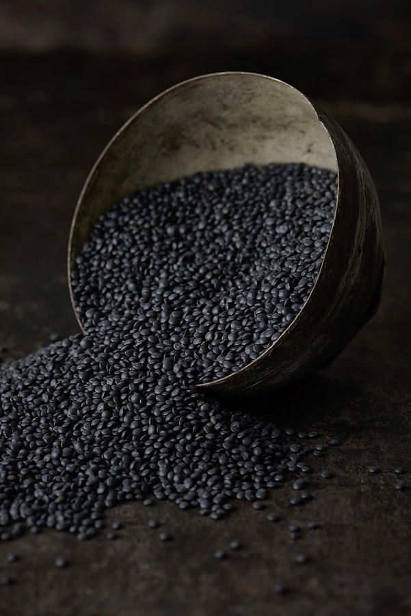 Upturned Metal Bowl With Black Lentils On A Dark Metal Background Photograph by Sylvia Meyborg