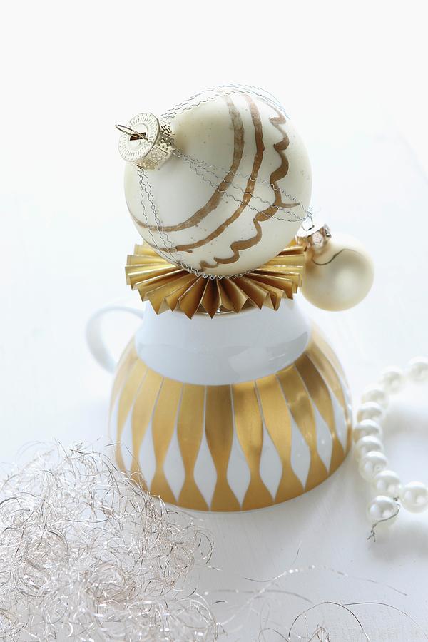 Upturned, Vintage Teacup With Gold Pattern And Hand-painted Christmas Bauble On Origami Paper Star Photograph by Regina Hippel